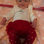 Oaklynn joined the competition — help win amazing prizes! baby, infant, smiling, headband, red_clothing, leggings, tutu, blanket, heart_pattern, soft_texture, lying_down, indoors, cute, happy, child, person, face, small_feet, cozy, warm