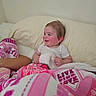 Caysen is registered to the contest to win money with this photo: baby, infant, child, smiling, laughing, sitting, bed, pillow, blanket, pink, white, stuffed_animal, toy, bedroom, indoors, portrait, face, short_sleeves, happy, cozy