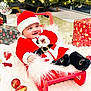 baby, black_boots, blanket, celebration, child, christmas_ornaments, christmas_tree, cute, decorations, festive, happy, holiday, indoor, presents, red, santa_claus_costume, seasonal, sled, smiling, white