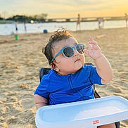 Shivin joined the competition — help win amazing prizes! baby, sunglasses, blue_clothing, beach, sand, sunset, baby_chair, child, outdoor, summer, sunlight, cute, portrait, footwear, person, infant, vacation, relaxation, sunshine, fun
