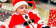 Shivin is registered to the contest to win money with this photo: baby, celebration, child, christmas_ornaments, christmas_tree, cozy, cute, decorations, festive, fur_trim, holiday, indoors, present, red_and_white, red_sled, santa_claus_costume, seasonal, smiling, soft_texture, wrapped_gift