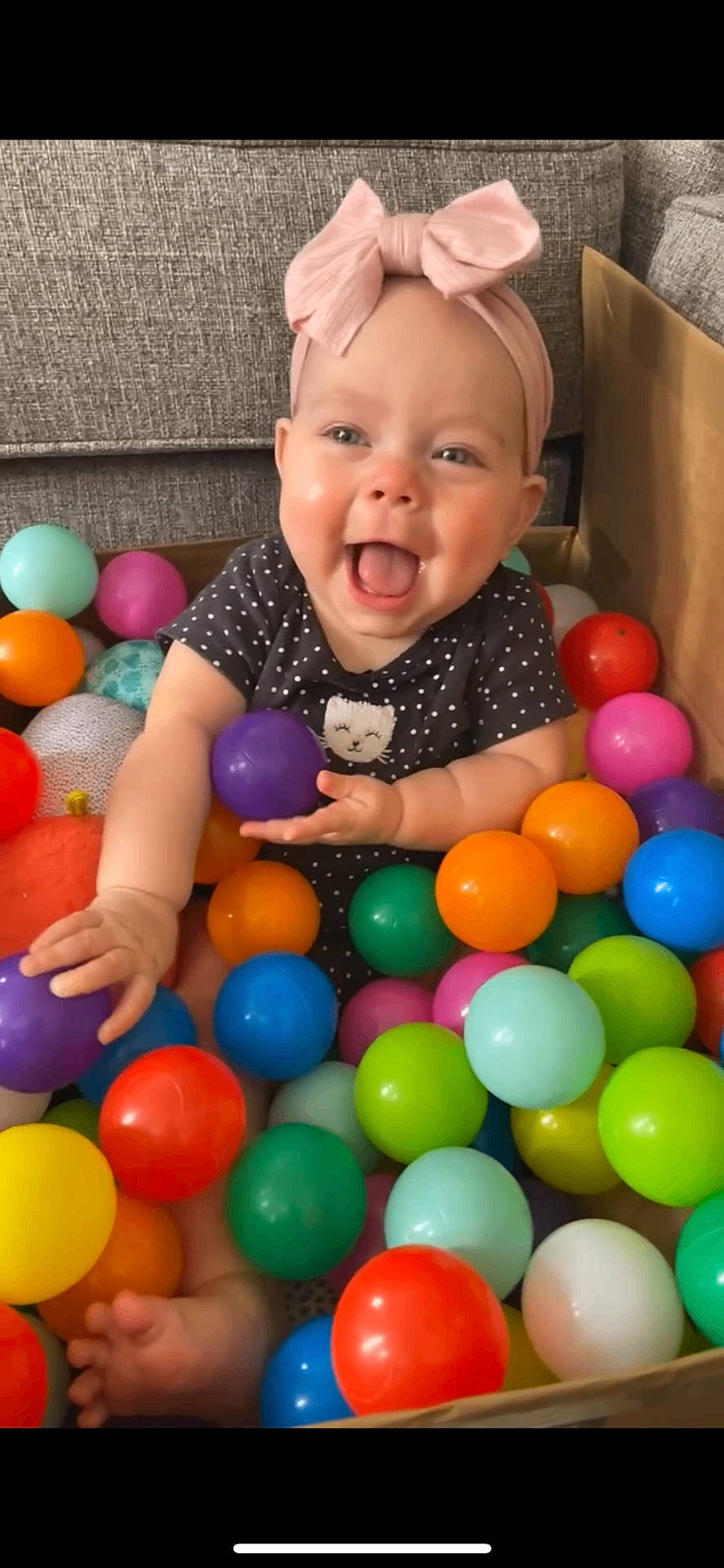 Amiyah joined the competition — help win amazing prizes! accessories, baby, babylaughing, balloon, clothing, couch, face, furniture, happy, hat, head, indoors, laughing, person, photography, playarea, portrait, smile, sphere, t_shirt