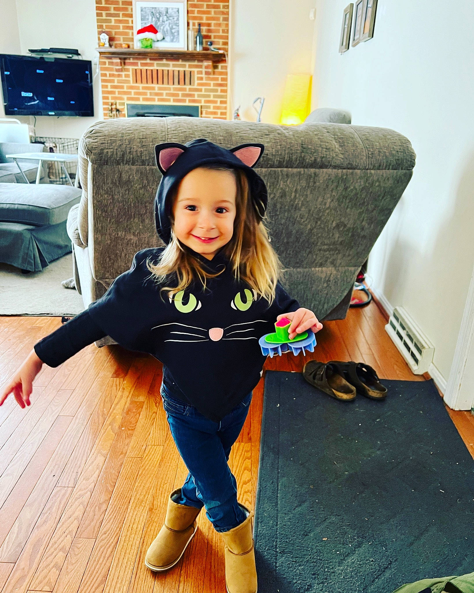 Liliana joined the competition — help win amazing prizes! child, comfort, couch, face, floor, flooring, happy, hardwood, head, headwear, joy, leisure, living_room, person, picture_frame, sleeve, smile, sportswear, standing, t_shirt