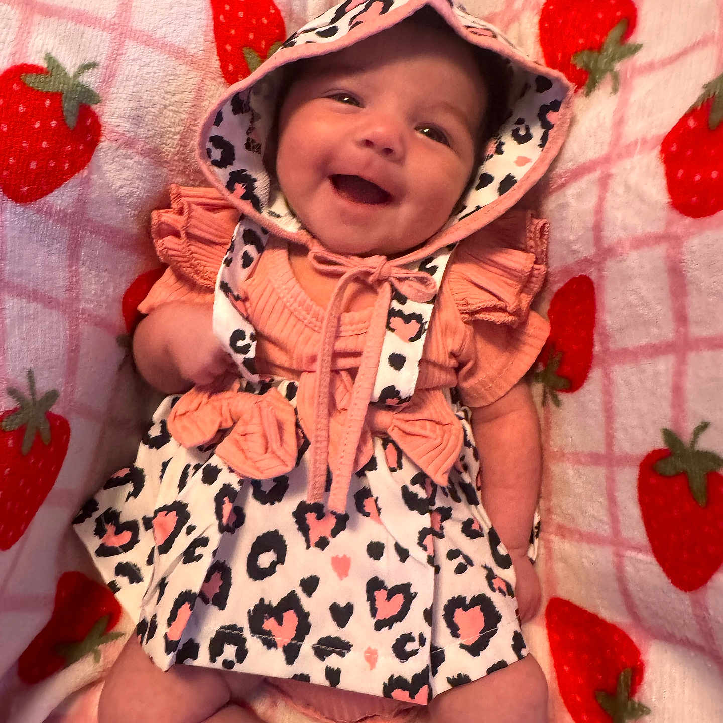 Violet joined the competition — help win amazing prizes! baby, infant, child, smiling, happy, portrait, hood, dress, frills, cow_print, strawberry_blanket, pink, coral, lying_down, indoor, close_up, face, eyes, baby_clothing, cute