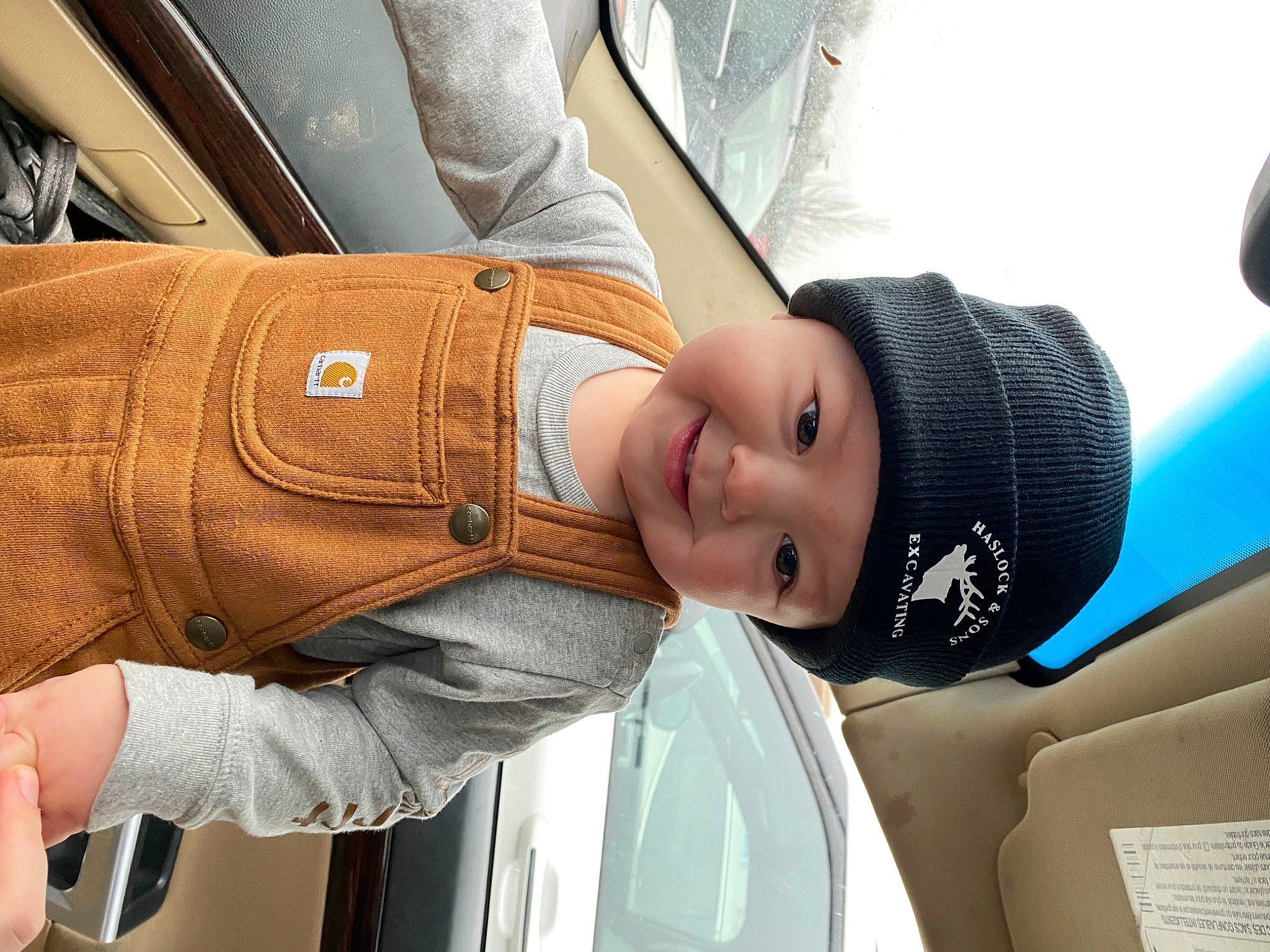 Charlie is registered to the contest to win money with this photo: arm, auto_part, automotive_design, automotive_exterior, car_seat, comfort, elbow, family_car, gesture, hand, headwear, joy, leisure, luxury_vehicle, motor_vehicle, passenger, person, personal_luxury_car, steering_wheel, street_fashion