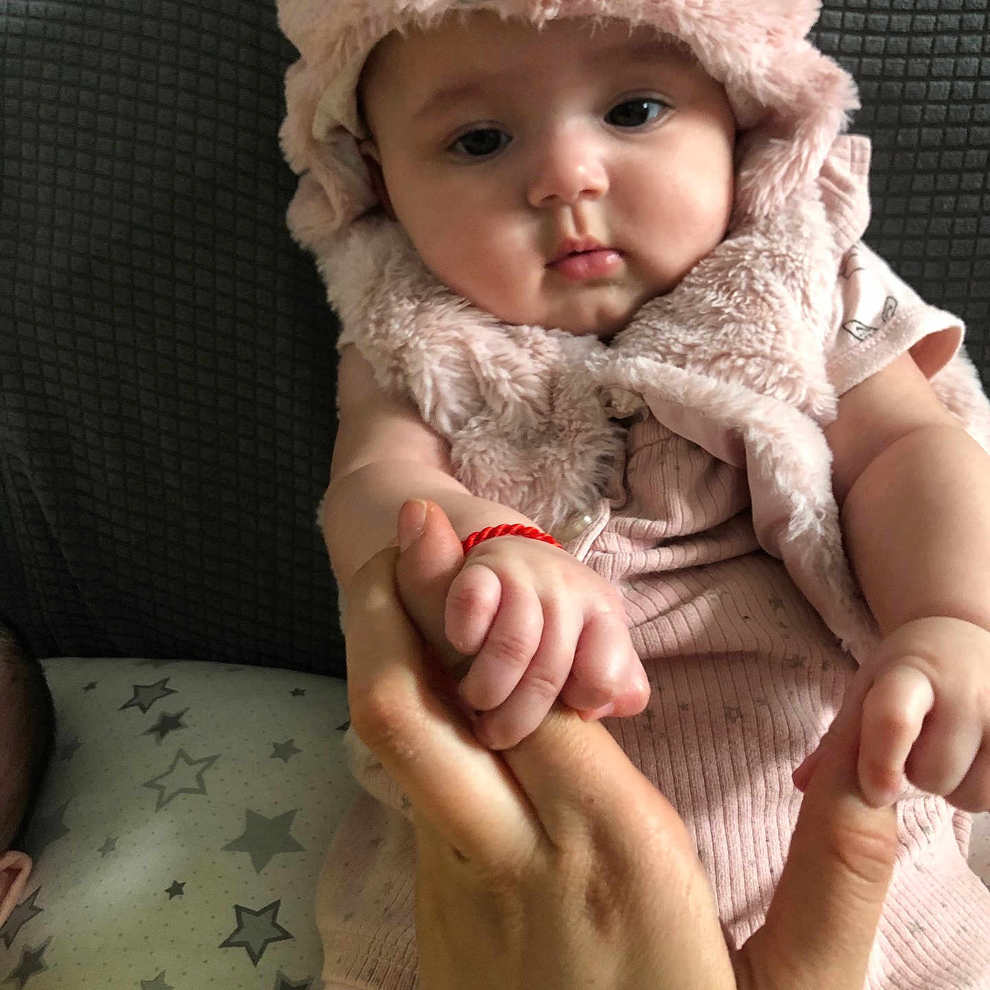 Isabella is registered to the contest to win money with this photo: baby, bodypart, bonnet, cap, clothing, coat, couch, face, finger, furniture, hand, hat, head, hood, jacket, newborn, person, photography, portrait, quilt