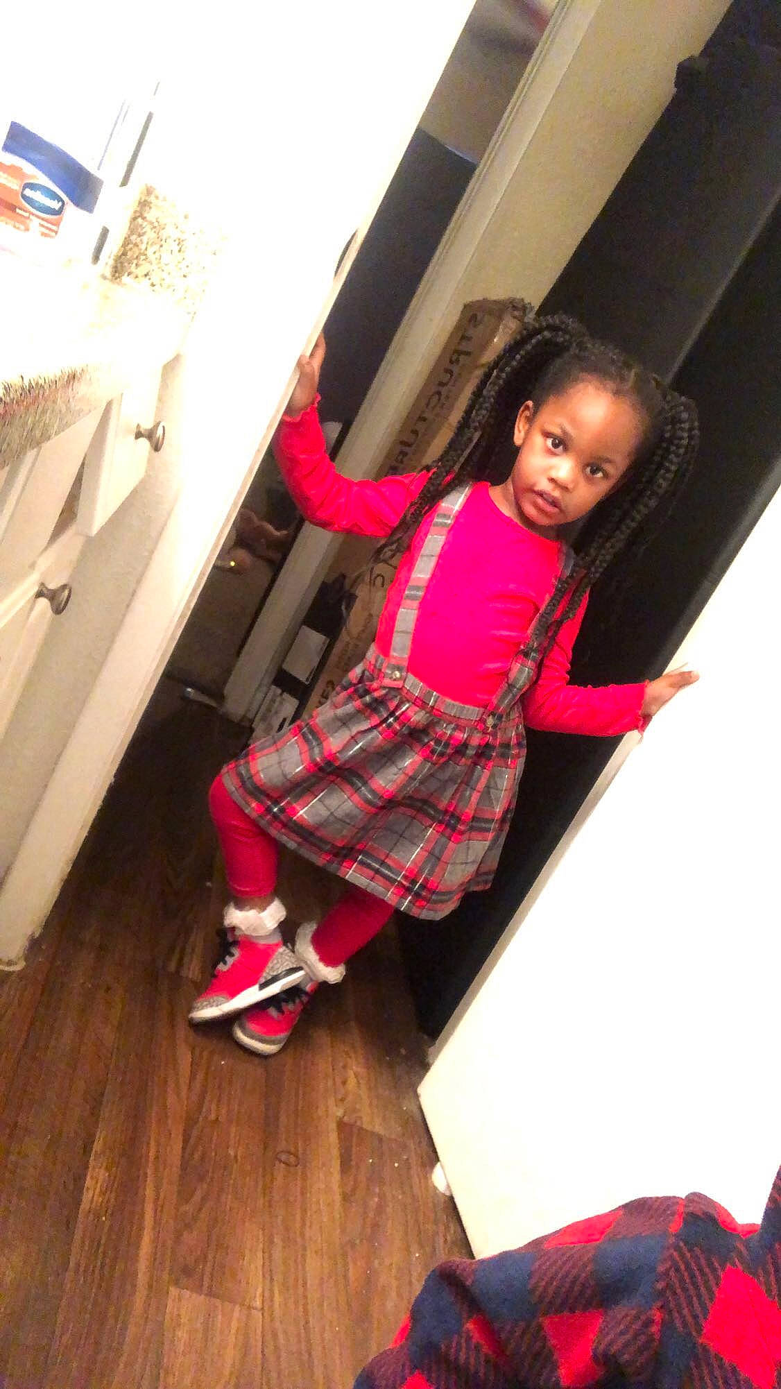 Harmony is registered to the contest to win money with this photo: dress, floor, flooring, human_leg, knee, leg, magenta, person, plaid, red, shoe, shorts, sneakers, sock, sportswear, standing, tartan, thigh, toddler, waist