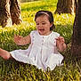toddler, child, grass, tree, outdoor, nature, smiling, happy, white_dress, barefoot, headband, sunlight, greenery, playful, sitting, young_child, portrait, daylight, cute, joyful