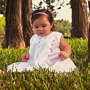 Isabella joined the competition — help win amazing prizes! child, toddler, grass, trees, outdoor, nature, white_dress, headband, pink, sitting, curious, baby, portrait, greenery, summer, cute, young, daylight, forest, innocence
