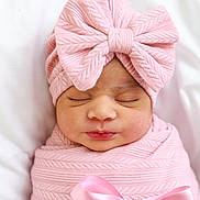 Isha is registered to the contest to win money with this photo: newborn, baby, infant, sleeping, portrait, pink, swaddled, blanket, bow, ribbon, knitwear, headband, peaceful, face, closed_eyes, indoors, bedding, soft_lighting, cute, photography