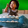 Joari a rejoint le concours — aidez-le/la à gagner de superbes lots ! toddler, child, smiling, hat, overalls, plush_toy, crocodile, bed, bedding, green_wall, indoor, happy, cute, portrait, person, clothing, furniture, toy, playful, young_child