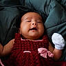 baby, infant, smiling, crocheted_dress, red_clothing, white_mitten, blanket, green_blanket, cozy, closeup, portrait, child, cute, happy, lying_down, soft_texture, indoors, person, newborn, warm