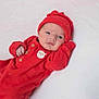 Dallas is registered to the contest to win money with this photo: baby, infant, newborn, red_clothing, hat, Santa_patch, lying_down, white_background, cute, portrait, child, face, eyes, small_hands, warm_clothing, cozy, holiday_theme, soft_texture, expression, indoors