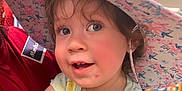Asuka joined the competition — help win amazing prizes! bright_lighting, child, close_up, curly_hair, cute, face, floral_hat, hat, holding, indoor, pastel_clothing, person, playful, portrait, shopping, short_sleeves, smile, store, toddler, young_child