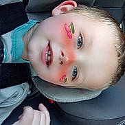 Logan is registered to the contest to win money with this photo: child, face_filter, car_seat, car_interior, blue_eyes, smiling, hand, blond_hair, seatbelt, young_child, cheeks, casual_clothing, partial_face, digital_sticker, playful, closeup, portrait, car_trip, happy, interior