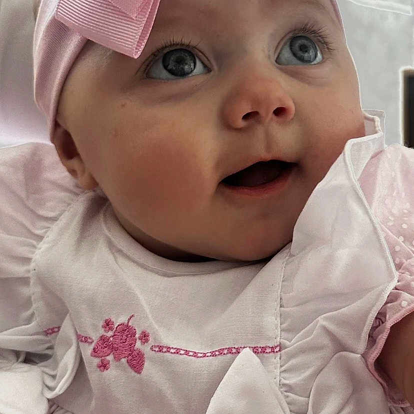 Kyla joined the competition — help win amazing prizes! adorable, baby, baby_girl, child, close_up, cute, dress, expression, eyes, face, happy, headband, indoors, infant, pink_bow, portrait, smiling, soft_lighting, white_clothing, young