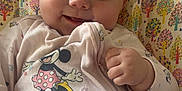 Kyla is registered to the contest to win money with this photo: baby, child, smiling, blue_eyes, blanket, minnie_mouse, clothing, hand, patterned_background, colorful, trees, cute, infant, portrait, soft_toys, happy, indoors, sitting, closeup, person
