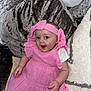 Kyla is registered to the contest to win money with this photo: baby, child, pink_dress, headband, smiling, happy, couch, pillow, plush, infant, cute, portrait, indoors, clothing, person, seated, young_child, soft_texture, comfortable, home