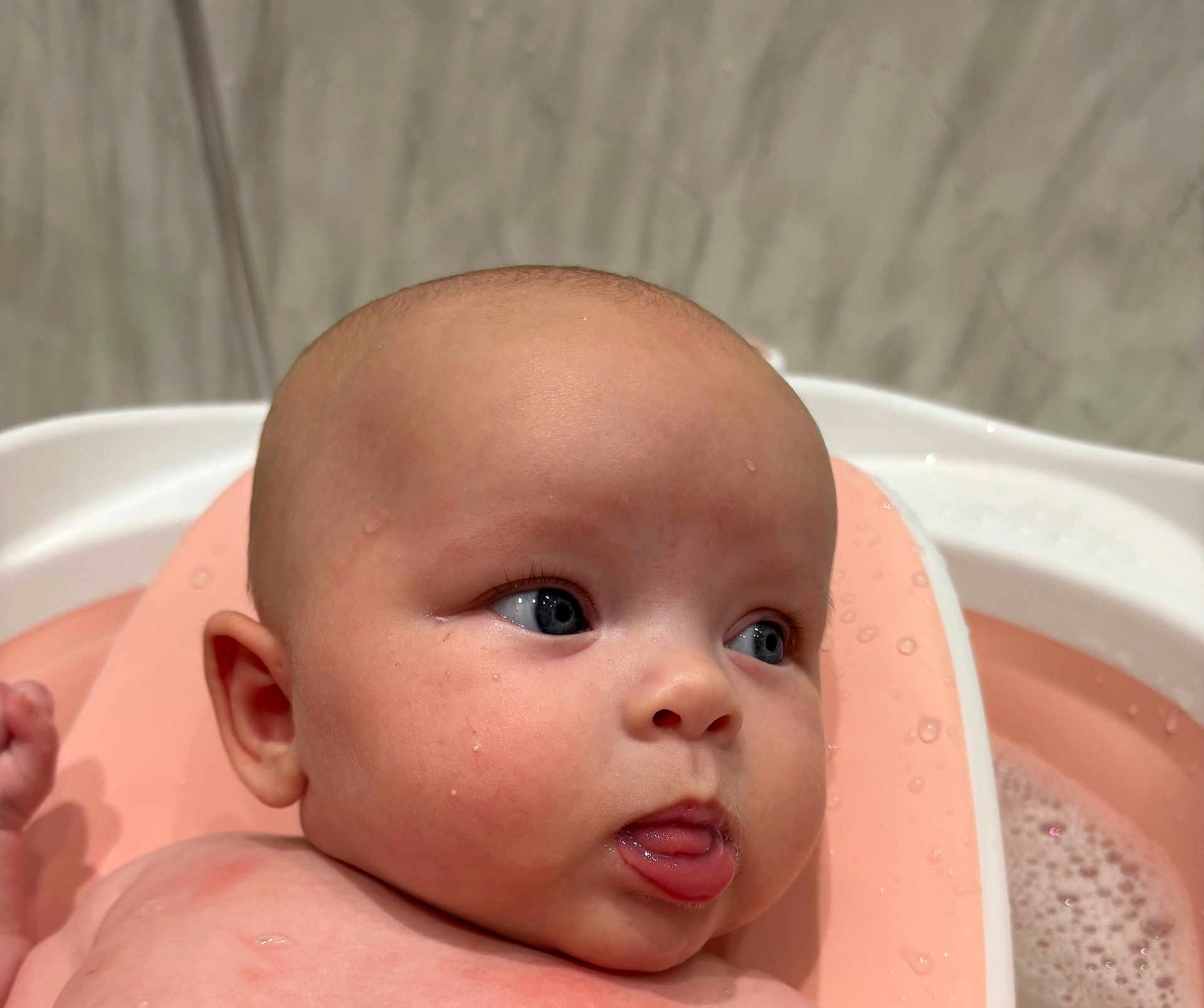 Marnie joined the competition — help win amazing prizes! baby, infant, face, skin, water, bath, bathtub, pink, droplets, tongue, expression, cute, child, head, closeup, person, young, bathroom, seat, wet