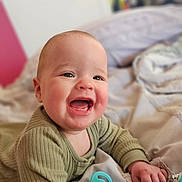 Violet joined the competition — help win amazing prizes! baby, smiling, infant, pacifier, green_clothing, bed, blanket, happy, cute, child, indoors, portrait, face, hand, soft_lighting, closeup, skin, expression, lying_down, cozy