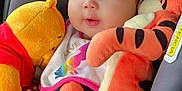 Rhianna is registered to the contest to win money with this photo: baby, child, plush_toy, winnie_the_pooh, tigger, car_seat, headband, cute, infant, toy, soft_toy, comfort, clothing, pink, orange, smiling, face, person, seat, child_safety