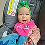 Rhianna is registered to the contest to win money with this photo: baby, child, car_seat, chicco, headband, green, pink_bib, plush_toy, smiling, happy, indoor, clothing, cute, infant, toy, person, seat, fabric, hand, face