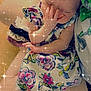 baby, child, infant, dress, bow, hand, face, sparkles, filter, colorful, floral, pattern, skin, person, sitting, arm, leg, indoors, softlight, cute