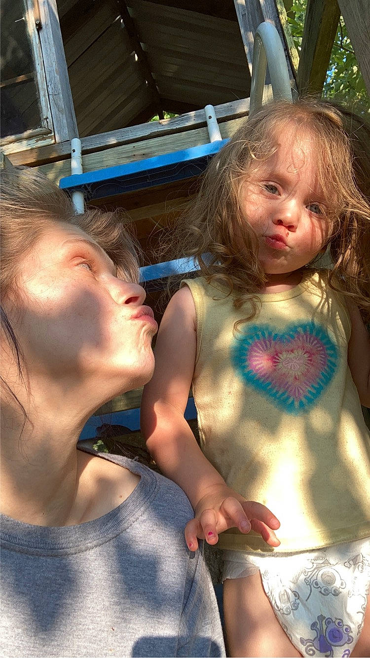 Aubrey is registered to the contest to win money with this photo: blond, child, cool, event, face, facial_expression, fun, gesture, grass, happy, iris, mammal, mouth, person, skin, summer, sunlight, t_shirt, toddler, tree