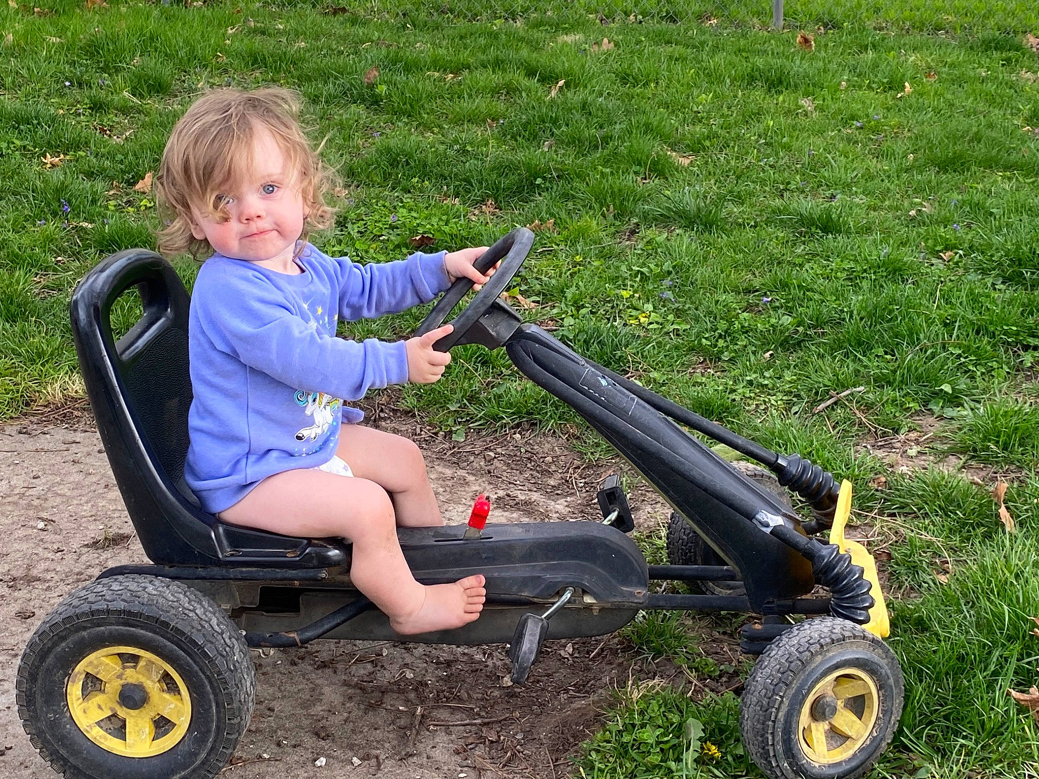 Aubrey is registered to the contest to win money with this photo: auto_part, automotive_tire, automotive_wheel_system, electric_blue, fun, grass, leisure, motor_vehicle, musical_instrument, people_in_nature, person, plant, play, recreation, riding_toy, sitting, smile, tire, toddler, vehicle