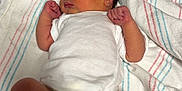 Sophia is registered to the contest to win money with this photo: newborn, baby, sleeping, infant, hospital, blanket, onesie, diaper, wristband, foot, hand, cute, peaceful, lying_down, skin, person, bed, striped_blanket, indoors, resting
