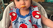 Elizabeth is registered to the contest to win money with this photo: baby_supplies, bib, box, child, clothing, expression, face, food, hair, hand, high_chair, home, indoor, mouth, person, seat, skin, spiderman, toddler, young_child