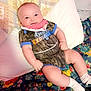 Kyler is registered to the contest to win money with this photo: baby, bed, bedroom, clothing, couch, cushion, dress, face, furniture, hat, head, homedecor, indoors, pants, person, photography, pillow, portrait, shorts, sitting