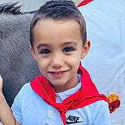 Milann a rejoint le concours — aidez-le/la à gagner de superbes lots ! child, boy, smile, portrait, closeup, face, eyes, short_hair, red_scarf, white_shirt, nike_logo, clothing, animal, fur, background, outdoor, happy, headshot, person, candid