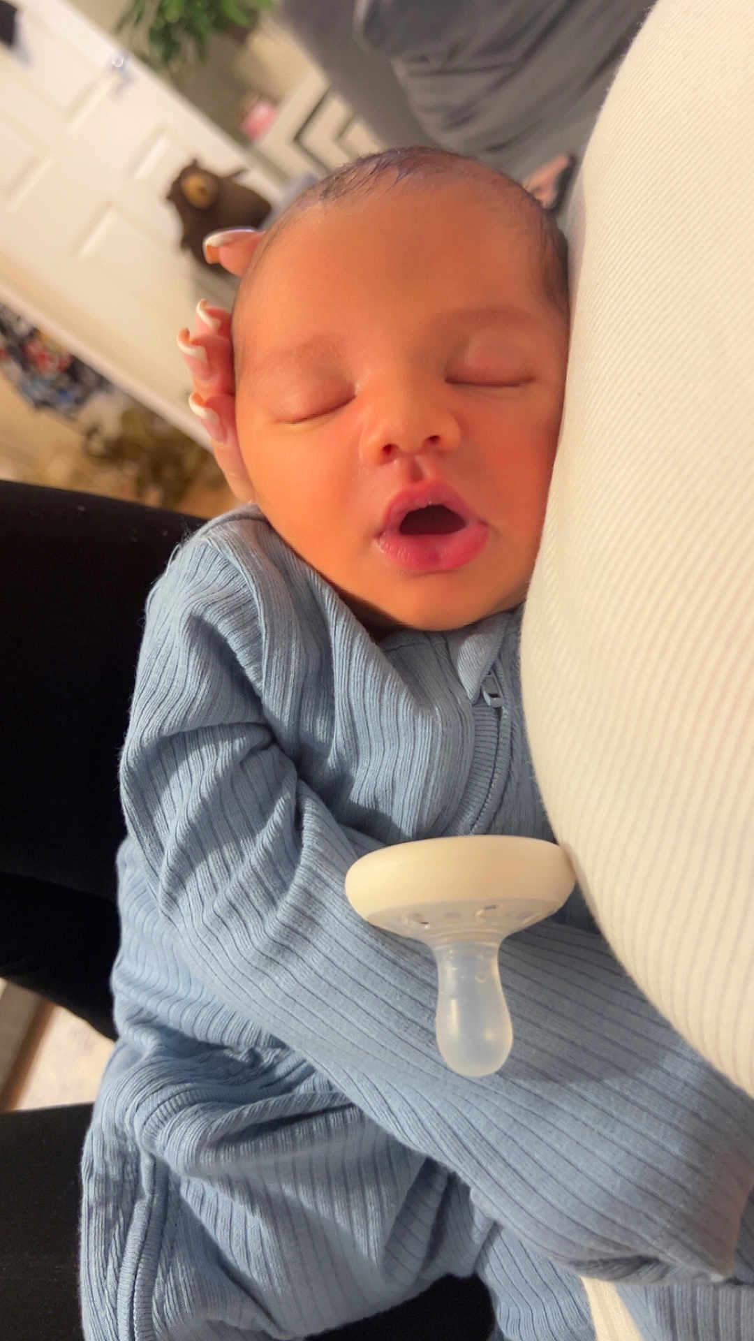 Khalil joined the competition — help win amazing prizes! baby, newborn, sleeping, blue_onesie, pacifier, hand, manicure, face, mouth_open, cozy, indoor, person, infant, soft_lighting, closeup, peaceful, resting, human, portrait, sleep