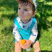 Isao participe au concours pour gagner de l'argent avec cette photo : baby, bottle, cap, casual, child, cute, daylight, drool, grass, greenery, hat, long_sleeve, nature, outdoor, overalls, playful, portrait, sitting, sunlight, toddler