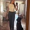 Harybo participe au concours pour gagner de l'argent avec cette photo : woman, dog, mirror, selfie, kitchen, tile_floor, casual_clothing, jeans, white_top, sneakers, handbag, chair, table, refrigerator, indoor, light, smile, pet, reflection, phone
