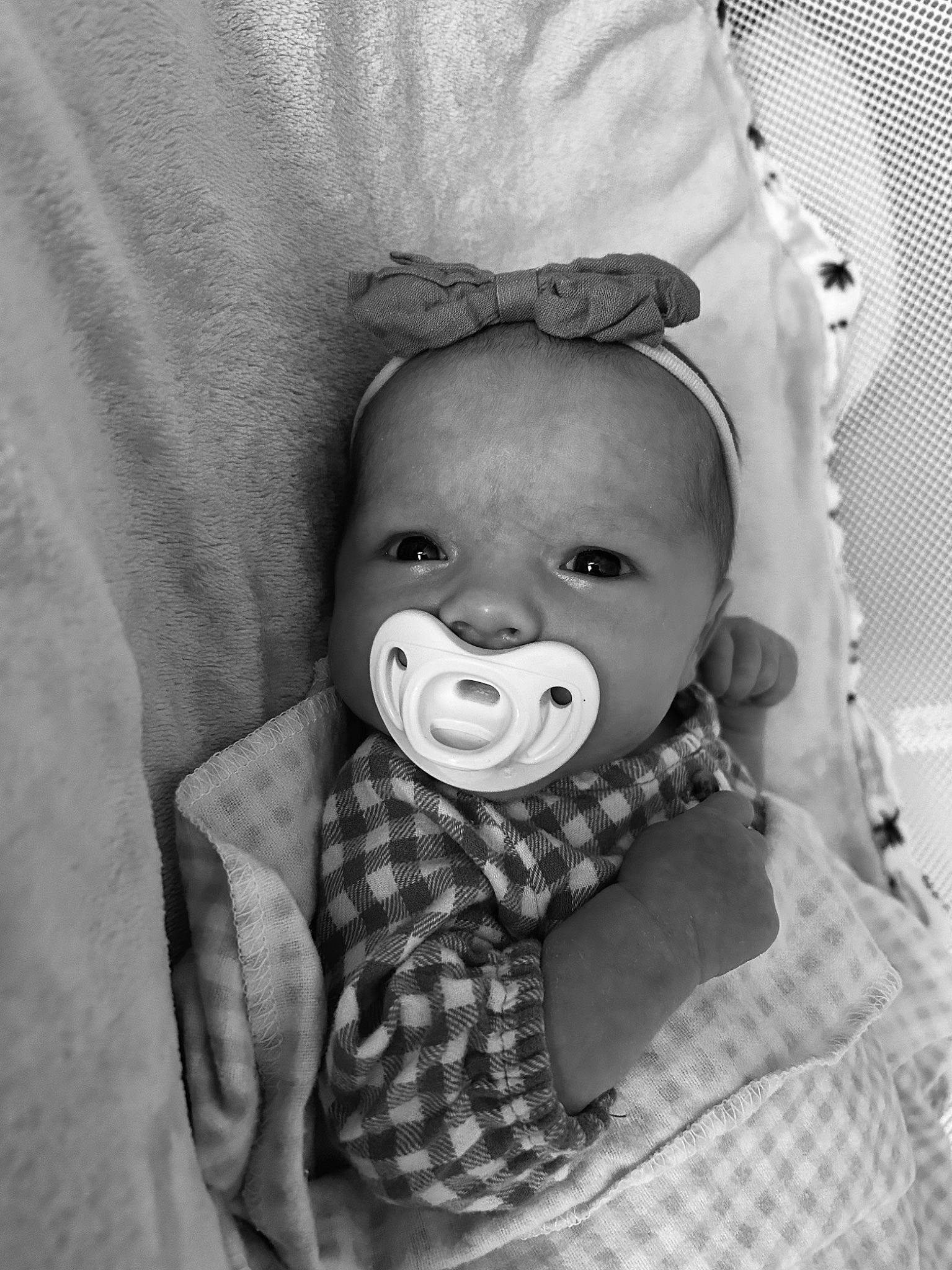 Peyton is registered to the contest to win money with this photo: baby, baby_toddler_clothing, black_and_white, cheek, comfort, eye, eyelash, gesture, hand, happy, headgear, monochrome, mouth, nose, person, skin, sleeve, style, textile, toddler
