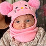 Nalia a rejoint le concours — aidez-le/la à gagner de superbes lots ! baby, child, pink_hat, pom_poms, scarf, knitwear, blue_eyes, face, portrait, cozy, warm_clothing, sweater, indoor, person, cute, infant, closeup, expression, soft_lighting, background