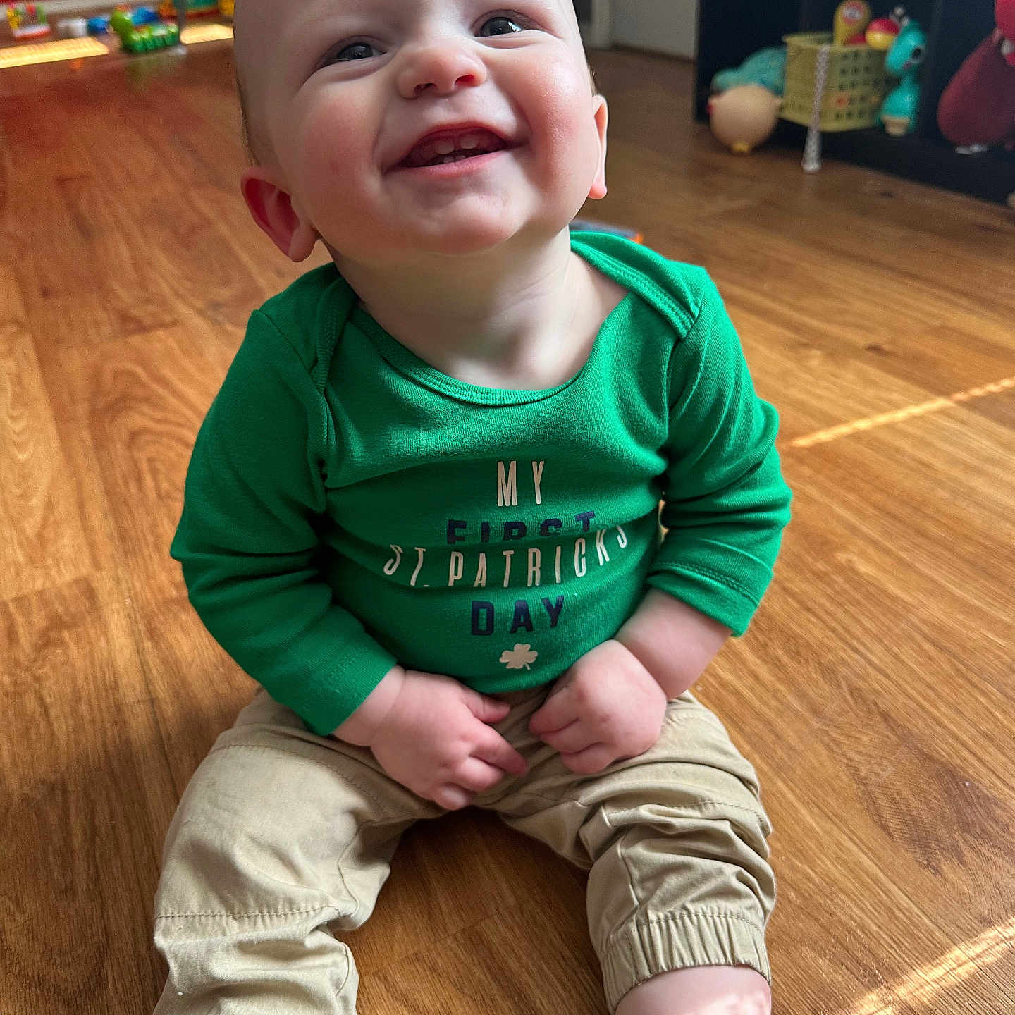 Izaak is registered to the contest to win money with this photo: baby, clothing, face, footwear, happy, hardwood, head, indoors, interiordesign, jeans, laughing, pants, person, photography, portrait, shoe, sitting, smile, t_shirt, wood