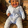 Bode is registered to the contest to win money with this photo: baby, child, infant, smiling, happy, portrait, hood, hooded_outfit, blue_clothing, jumpsuit, sitting, blanket, patterned_blanket, indoor, face, eyes, mouth, bare_feet, family_photo, cute