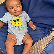 Bode joined the competition — help win amazing prizes! baby, infant, child, portrait, smiling, sitting, outdoor, camping_chair, blue_chair, onesie, sunglasses_design, smiley_face, barefoot, wooden_surface, woven_mat, close_up, front_facing, happy, casual_clothing, photography