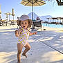 Suzy participe au concours pour gagner de l'argent avec cette photo : toddler, child, swimsuit, hat, poolside, umbrella, mountain, sunlight, shadow, concrete, vacation, outdoor, summer, barefoot, expression, person, water, lounge_chair, recreation, nature