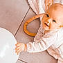 baby, child, infant, balloon, pajamas, blanket, floor, tile, hand, face, blue_eyes, smile, crawling, curious, indoors, soft_texture, light_skin, playful, young, cozy