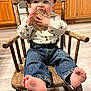 Ezra is registered to the contest to win money with this photo: baby, child, rocking_chair, wooden_chair, denim_jeans, shirt, cap, barefoot, cute, playful, indoor, kitchen, wooden_floor, home, smiling, person, furniture, plaque, sitting, young_child