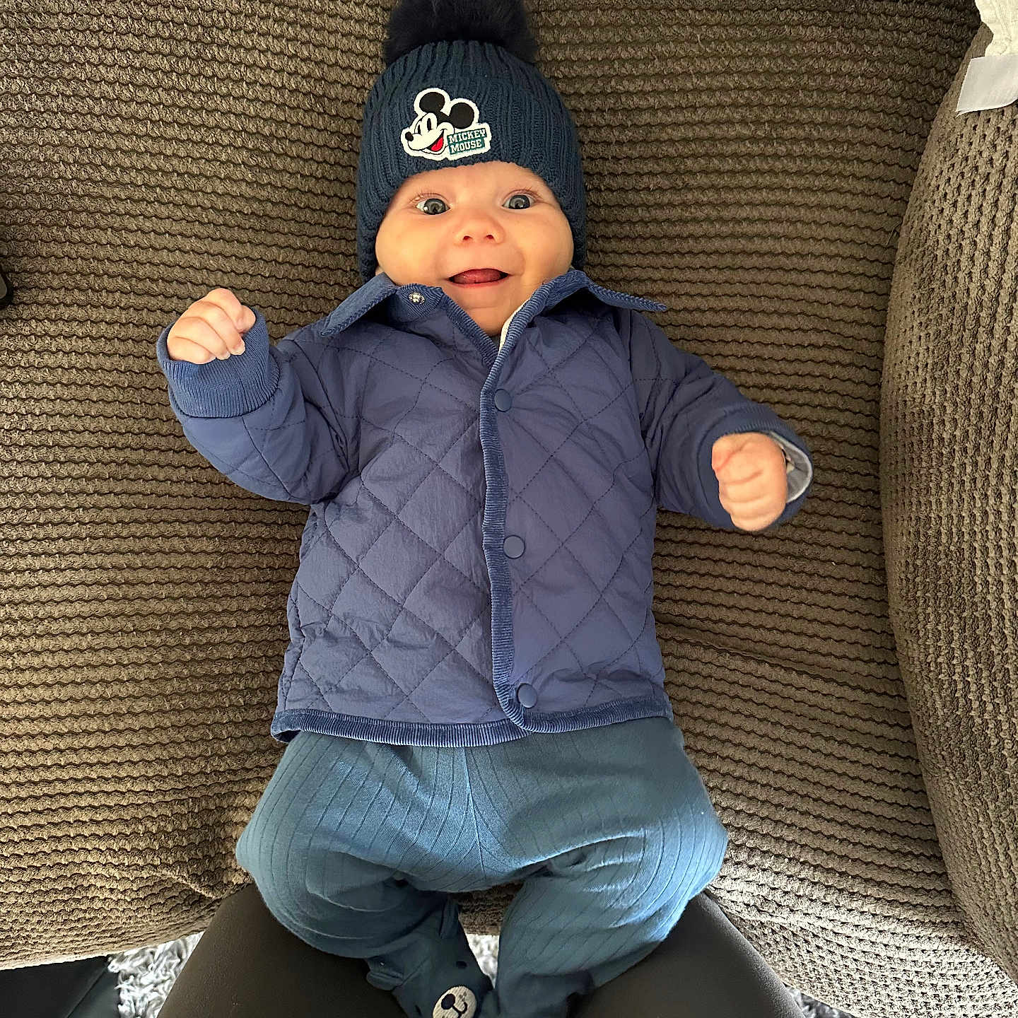 Joey is registered to the contest to win money with this photo: baby, cap, clothing, coat, couch, cushion, face, furniture, hat, head, homedecor, jacket, jeans, knitwear, pants, person, photography, portrait, sitting, sweater