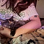 cat, kitten, tortoiseshell, person, arm, hand, tattoo, t_shirt, floral_pattern, blanket, cozy, indoor, cuddle, fur, holding, sleepy, ring, portrait, soft_lighting, relaxation