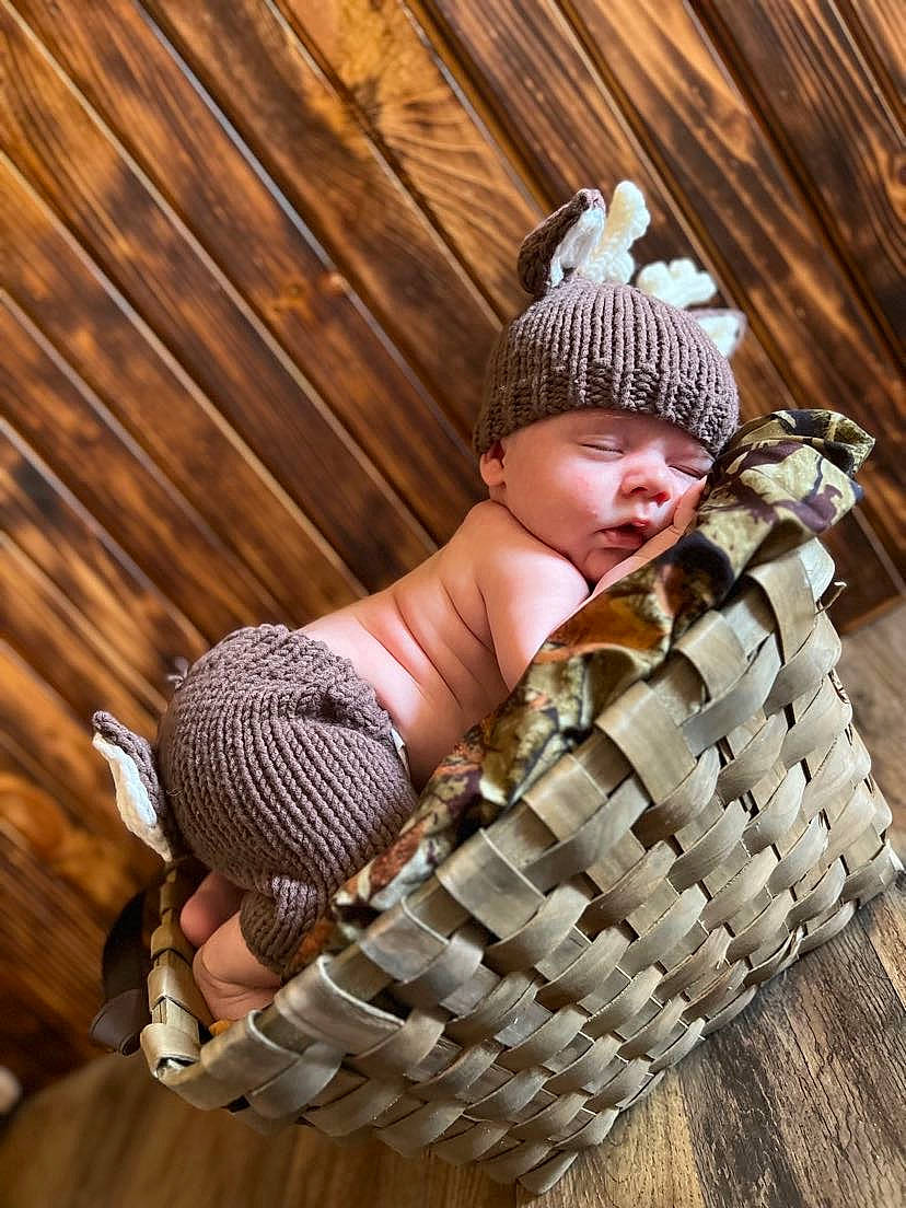 Lance is registered to the contest to win money with this photo: baby, baby_products, baby_toddler_clothing, basket, beanie, cap, child, fashion_accessory, flooring, fun, goggles, grass, hardwood, headwear, pattern, person, play, sitting, toddler, wicker