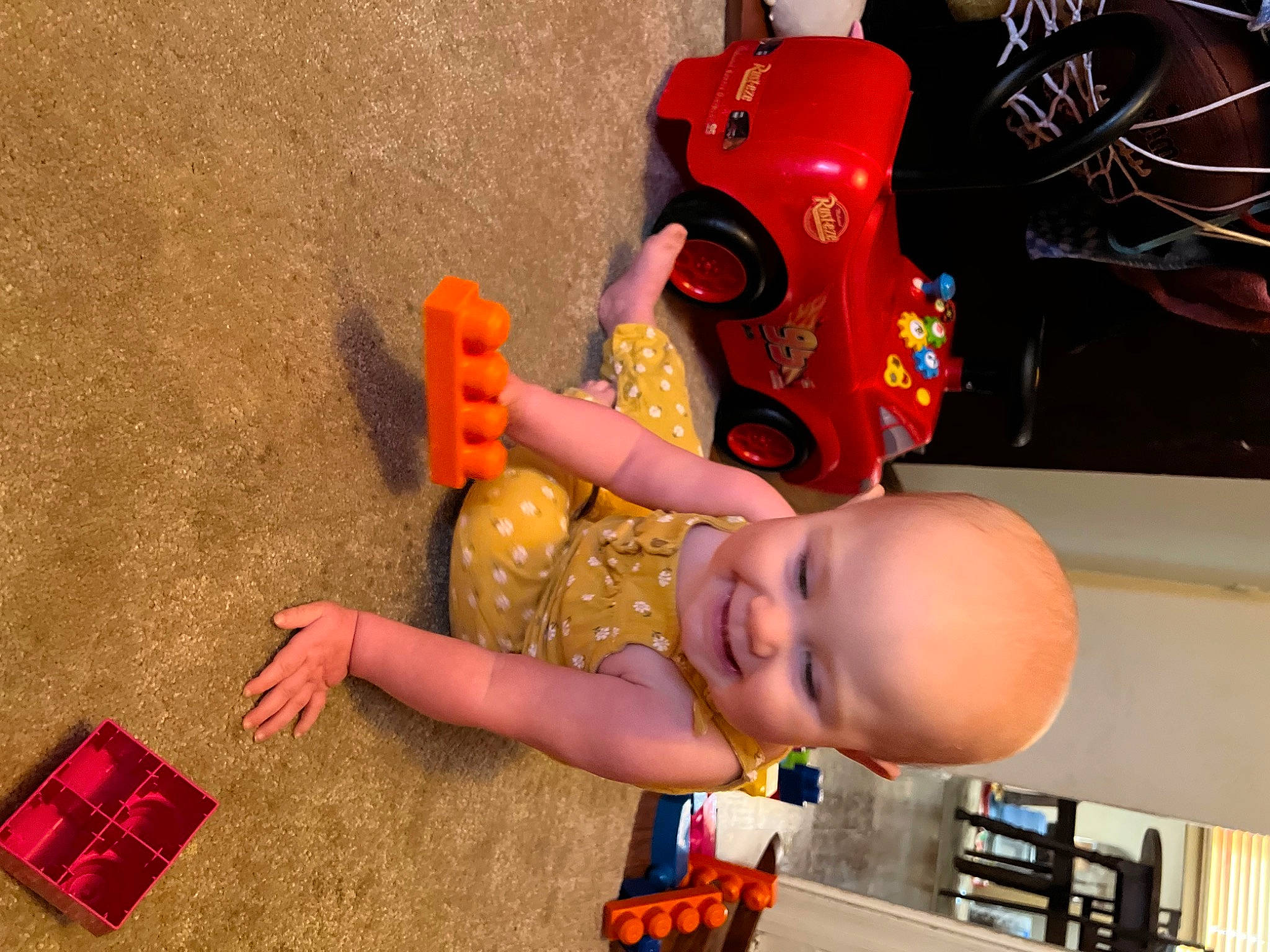 Allie is registered to the contest to win money with this photo: baby, baby_products, baby_toys, child, finger, fun, games, happy, hat, joy, leisure, orange, party, person, play, room, smile, toddler, toy, toy_vehicle