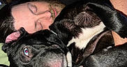 Dallas is registered to the contest to win money with this photo: man, dog, sleeping, cuddling, black_dog, white_markings, bed, pillow, indoor, closeup, human_face, pet, resting, nap, beard, ear, nose, fur, collar, comfort