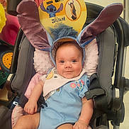 Adaline joined the competition — help win amazing prizes! baby, child, stroller, portrait, smiling, indoors, shopping, disney, stitch, headband, costume, blue_clothing, bib, overalls, seated, infant, face, retail_store, colorful, happy